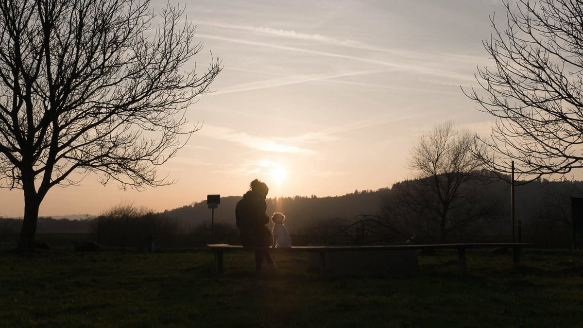 Kuscheln mit Hund auf einem hundefreundlichen Campingplatz bei Sonnenuntergang